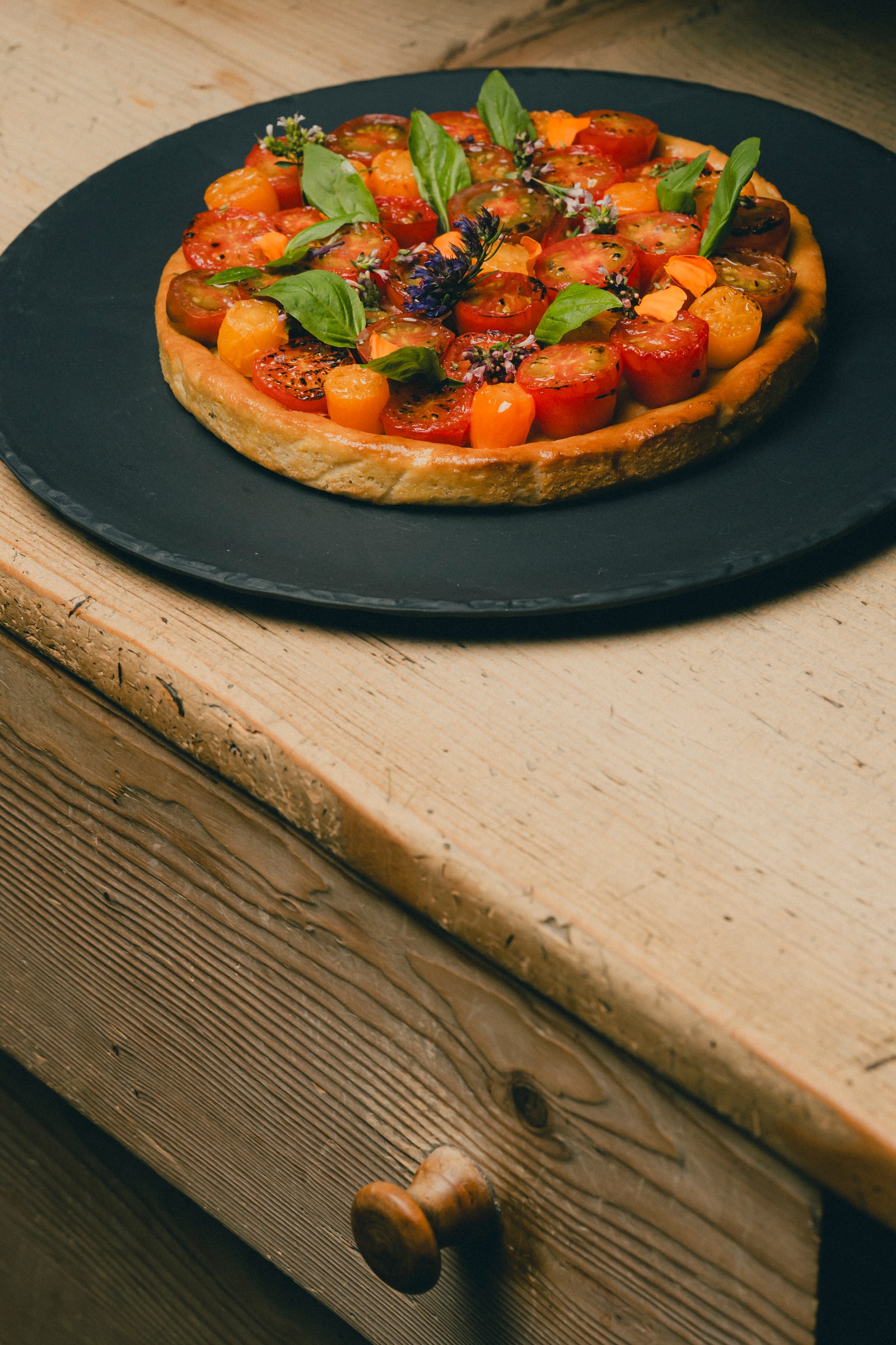 Tarte aux tomates, pesto d’herbettes et vieux raclette
